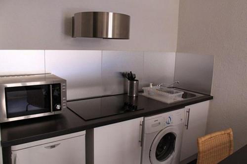 a kitchen with a microwave and a washing machine at Studio Molière in Montpellier