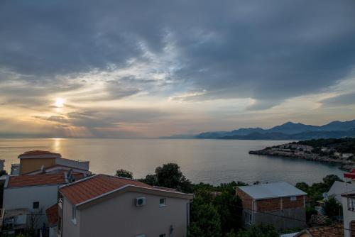 a view of a body of water with the sun setting at Apartments Tina in Utjeha