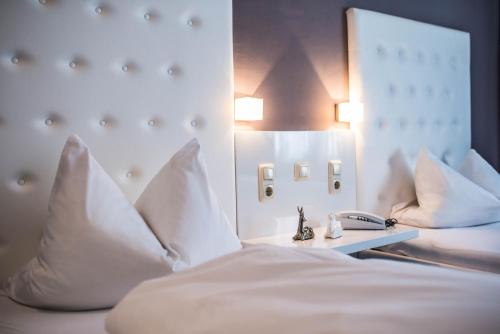a bedroom with a bed with white pillows at Hotel Domizil in Ingolstadt