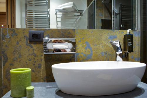 a bathroom with a white sink and a green candle at Solo Experience Hotel in Florence