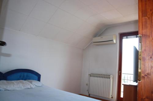 ein Schlafzimmer mit einem blauen Bett und einem Fenster in der Unterkunft Prosper in Sarajevo