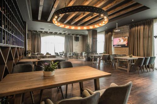 a restaurant with tables and chairs and a chandelier at Zaara Estate Winery Hotel & SPA in Glavan