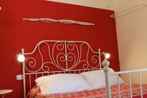 a red bedroom with a bed with a metal headboard at Angels'Home L&R in Pizzo