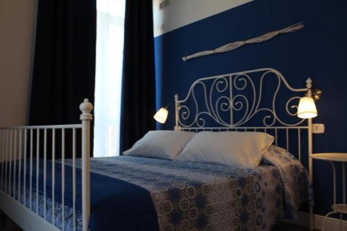 a bedroom with a bed with a blue wall at Angels'Home L&R in Pizzo