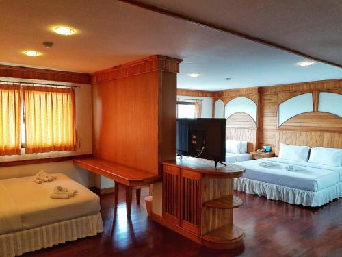 a bedroom with two beds and a flat screen tv at White Sand Princess in Ko Chang