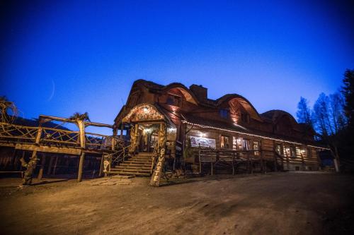 a large log cabin with stairs leading up to it at Troll in Cisna