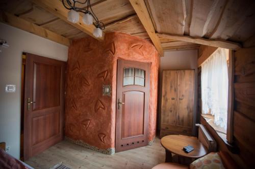 a room with a wooden wall with a door at Troll in Cisna
