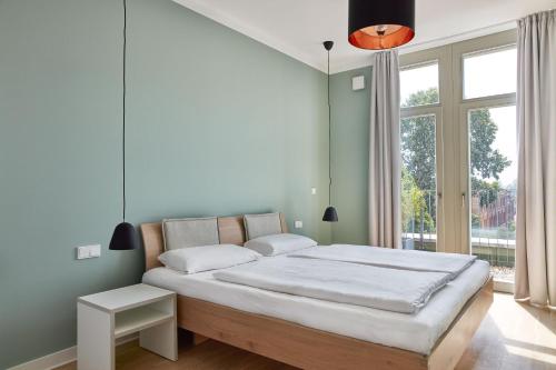 a bedroom with a large bed and a large window at Park Penthouses Insel Eiswerder in Berlin