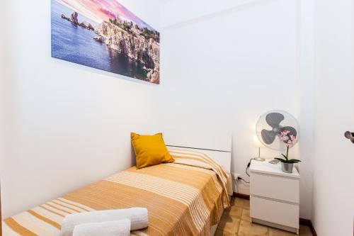- une chambre avec un lit et un oreiller jaune dans l'établissement Sicilia Etna Mare, à Mascali