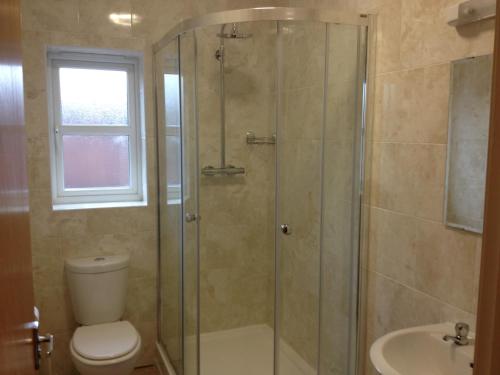 a bathroom with a shower and a toilet and a sink at The Waverley Hotel in Crewe