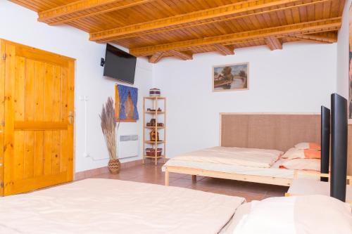 a bedroom with a bed and a wooden door at Bence Apartman in Tiszabábolna