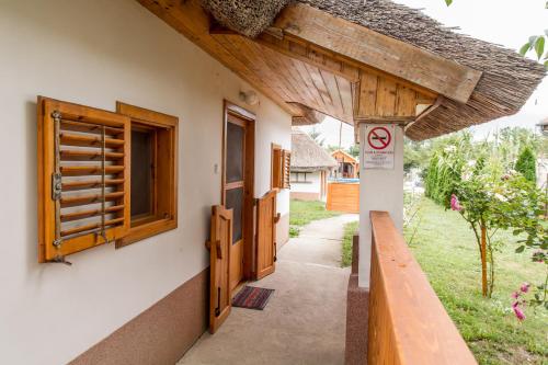 a building with a door and a window and a sign at Bence Apartman in Tiszabábolna