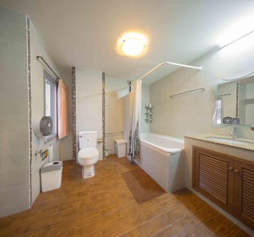 un bagno con un water, una vasca e un lavandino di Augusta a Bangkok