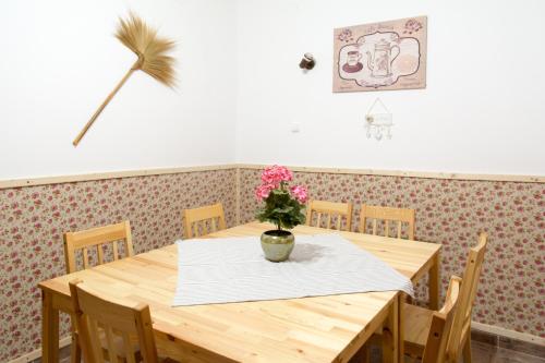 a dining room table with a vase of flowers on it at Bence Apartman in Tiszabábolna