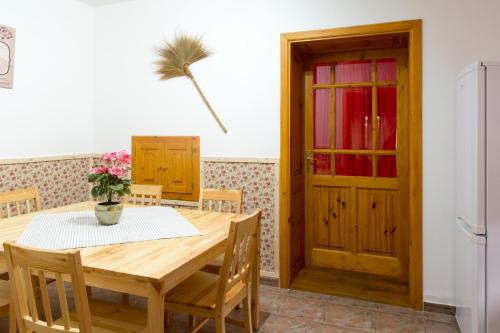 a dining room with a table and a refrigerator at Bence Apartman in Tiszabábolna