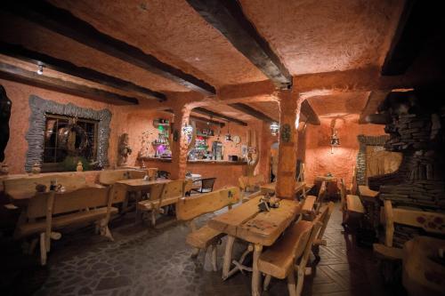 restauracja z drewnianymi stołami i ławkami w pokoju w obiekcie Troll w Cisnej