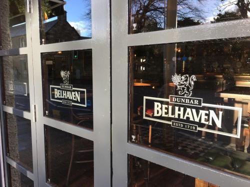 a window of a brewery with signs on it at Greyfriars Inn by Greene King Inns in St. Andrews