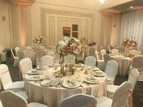 a banquet hall with tables and chairs and flowers at Tsarsko Selo Spa Hotel in Sofia