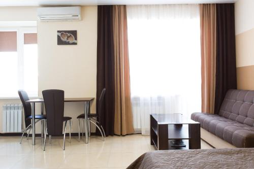 a hotel room with a couch and a table and chairs at Luxury Studios on Nauki Avenue in Kharkiv