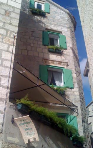 a building with green windows and plants on it at Villa Kuljis in Komiža