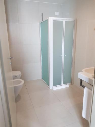 a bathroom with a toilet and a glass shower stall at Best Western Plus Hotel Monza e Brianza Palace in Cinisello Balsamo