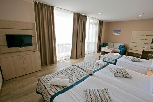 a hotel room with two beds and a flat screen tv at Royal Grand Hotel and Spa - All Inclusive and Free beach accsess in Kavarna
