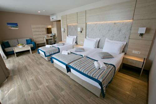 a hotel room with two beds and a couch at Royal Grand Hotel and Spa - All Inclusive and Free beach accsess in Kavarna