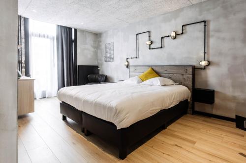 a bedroom with a large bed in a room at Upstairs Hotel in Ostend