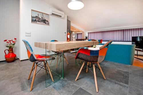 a dining room with a wooden table and chairs at Lakovich Sea view Apartments in Rovinj