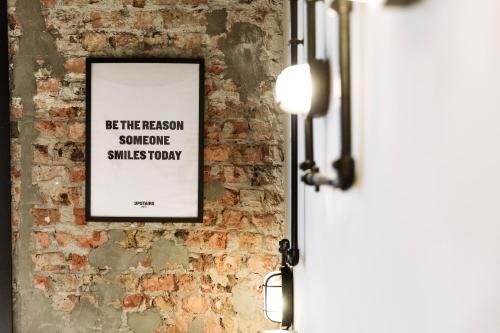 a picture on a brick wall with a framed sign at Upstairs Hotel in Ostend