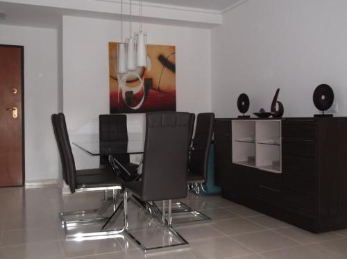 ein Esszimmer mit schwarzen Stühlen und einer Kommode in der Unterkunft Beautiful 3 bed, 2 bath modern apartment in Los Alcázares