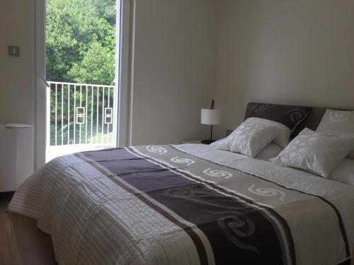 a bed in a bedroom with a large window at Villa Carmen in Opatija