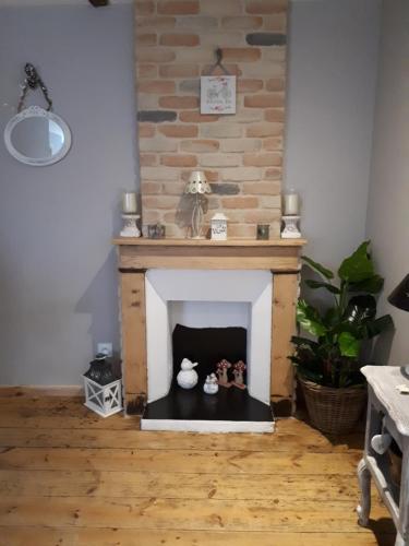 a living room with a fireplace with two vases at Chambres d hôtes Le clos des vins d anges in Saint-Pierre-des-Champs