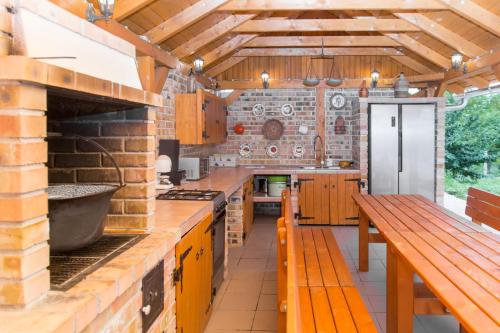 an open kitchen with wooden cabinets and a stone wall at Bence Apartman in Tiszabábolna
