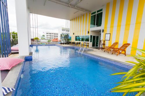 a swimming pool with blue water in a building at The Bridge Residence Hotel in Kanchanaburi City