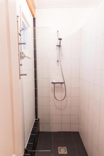 a shower in a white tiled bathroom at B&B "de Wingerd" in Bruchterveld