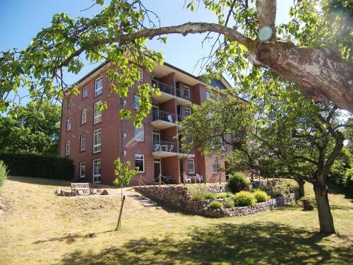 ein großes rotes Backsteingebäude mit einem Baum davor in der Unterkunft Haus Roland- Whg 23 mit Schwimmbad und Sauna in Zinnowitz