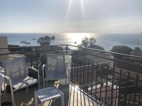 Un balcón con sillas y vistas al océano. en Albergo Milazzo Inn AiMori en Milazzo