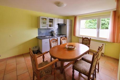 a kitchen with a table and chairs and a kitchen with a stove at Pension " Zu den Linden" Trin in Trinwillershagen