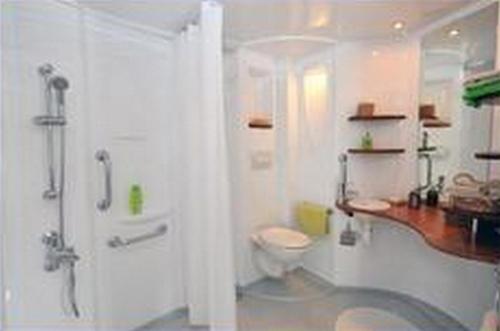 une salle de bain blanche avec toilettes et douche dans l'établissement Camping Au Bord de l'Aisne, à Guignicourt