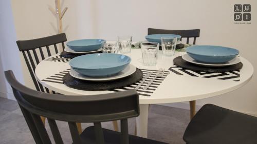 a white table with blue bowls and plates on it at Ludi Studios in Pompei