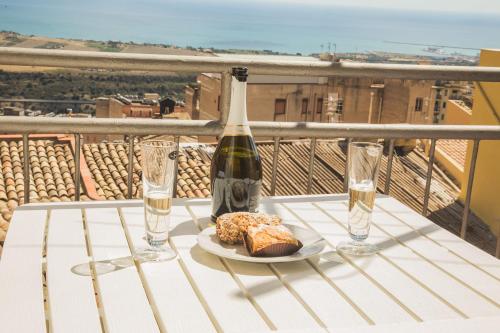 uma garrafa de vinho e um prato de comida numa mesa em B&B Alla Cattedrale em Agrigento