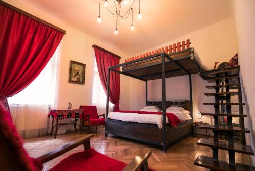 - une chambre avec un lit à baldaquin et des rideaux rouges dans l'établissement Folkloric Loft - Sibiul vechi, à Sibiu