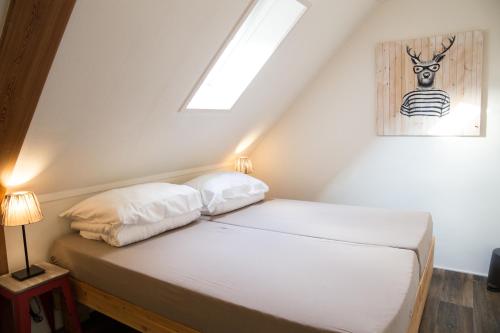 a bedroom with a white bed with a skylight at B&B "de Wingerd" in Bruchterveld