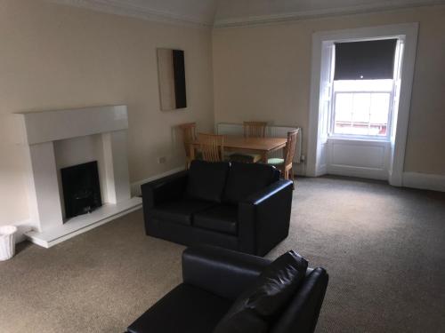 a living room with a couch and a chair and a table at Smithyends Apartments in Cumbernauld