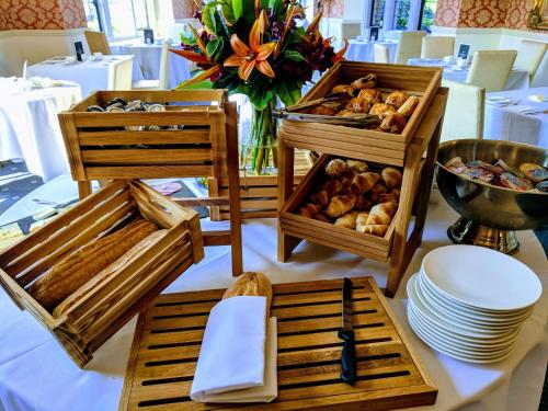 Ein Tisch, bedeckt mit Holztabletts mit verschiedenen Speisen in der Unterkunft Broome Park Hotel in Canterbury