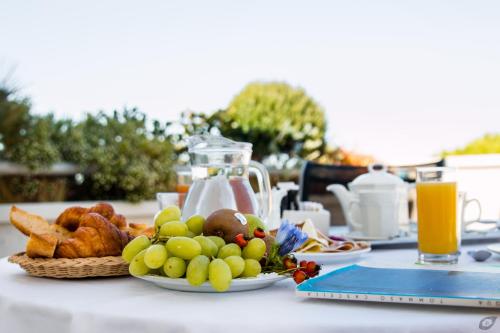 a table with a plate of fruit and bread on it at Verdeluna ApartHotel in Marina di Pietrasanta