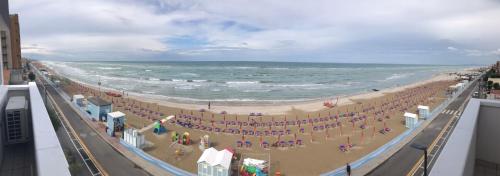a beach with a crowd of people and the ocean at Hotel Villa Joseph in Marotta