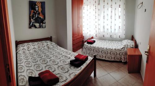 1 dormitorio con 2 camas y ventana en Apartament Joni, en Golem