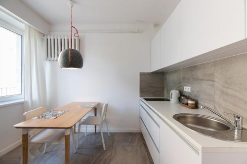 a kitchen with a wooden table and a sink at Apartament w sercu miasta in Łódź
